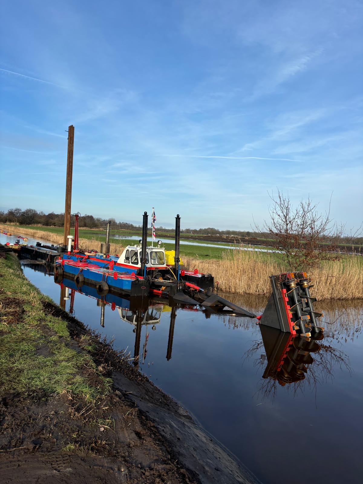 Baggerwerkzaamheden bij zonsondergang